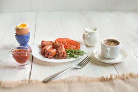 Breakfast in rustic style  boiled egg, sausage, salad, tomato, coffee)の写真素材