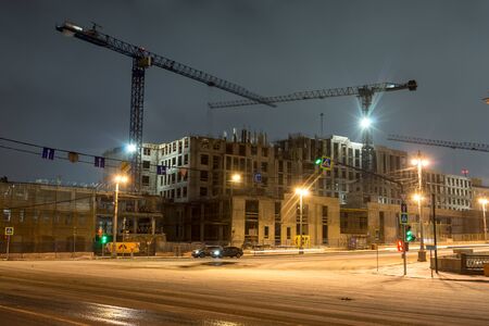 Lightening multi-storey buildings under construction and cranes at night.の写真素材