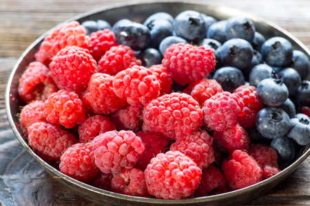 Berry fruits in a bowl blueberries, raspberries. Sweet summer fruits.