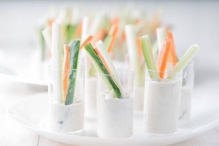 Glases with cream sauce for fresh carrot, cucumber and celery for catering wedding ceremony.の写真素材