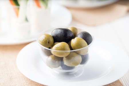 Green and black olive in a glass bownの写真素材