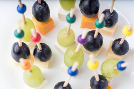 Canapes of Grapes, olives and cheese on white backgroundの写真素材