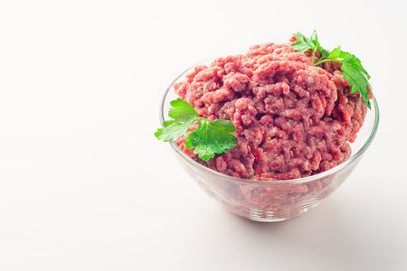 Fresh raw ground beef in glass bowl isolated on whiteの写真素材