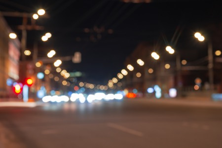 Nights lights of the big city, the night avenue with road markings and headlights of the approaching cars.の写真素材