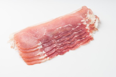 Raw bacon rashers isolated on white backgroundの写真素材