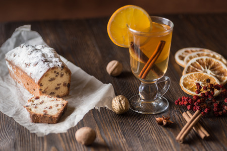 Traditional hot toddy winter drink with spices recipe. Fresh homemade cake holiday on a wooden background.の写真素材