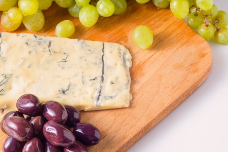 Brie cheeses, honey, grapes, olive on a white background. Top view. Food background.の写真素材