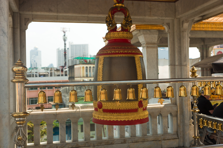 Ring bells in temple. Golden metal bell/ Big brass Buddhist bell. Ringing bell in temple is belief auspicious. Bangkok, Thailandの写真素材