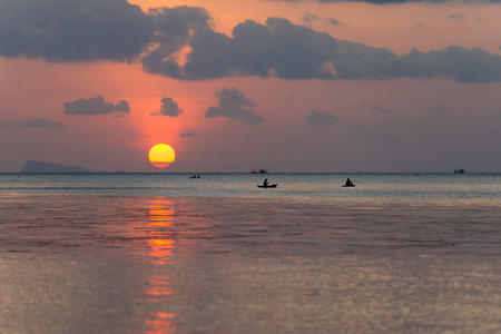 Beautiful colorful golden red sunset at the sea with dramatic clouds and sun shiningの写真素材
