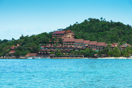 Turquoise sea  and bungalow hotel on sand beach - nature vacation backgroundのeditorial素材