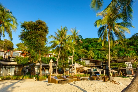 Outdoor view with umbrella and chair on a sand beach in luxury hotel and resort at sunrise time for travel and vacationのeditorial素材
