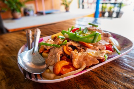 Stir fried  pork with  in a plate on wooden table. Asian style food conceptの写真素材