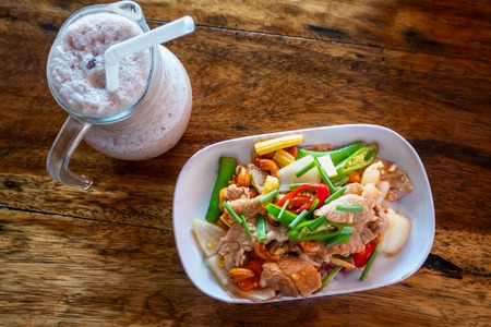 Stir fried  pork with  in a plate on wooden table. Asian style food conceptの写真素材