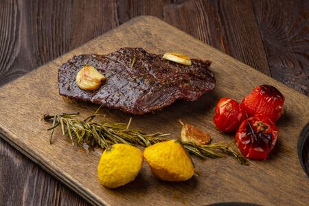 Grilled beef barbecue Striploin steak and vegetables tomatoes and squash on cutting board close-upの写真素材