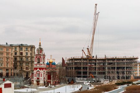 Construction crane at a construction site. Winter, unfinished building on a city street.の写真素材