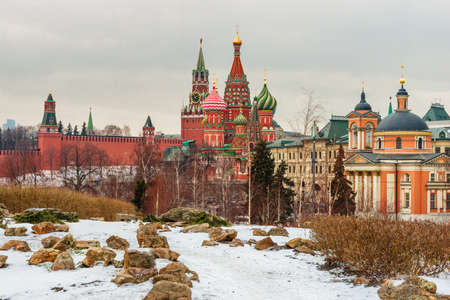 Beautiful winter cityscape with the view from Zaryadye park on the covered snow Spasskaya Tower (Saviorâs Tower) of Moscow Kremlin and St. Basilâs Cathedral framed by white trees.のeditorial素材