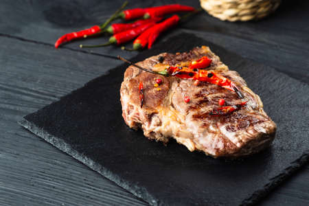 Fresh raw Prime Black Angus beef steaks on stone board: Striploin, Rib Eye. Top view. On a dark backgroundの写真素材