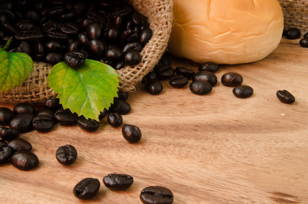 coffee beans in sack and bread on wooden backgroundの写真素材