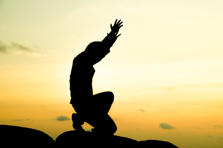 praying man on beautiful sky backgroundの写真素材