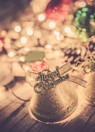 christmas jingle golden bell deco with rusty gold light bulb on wood background with copy spaceの写真素材