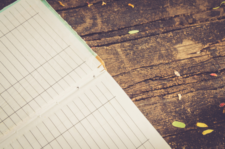 empty book and leaf on wooden board background , vintage toneの写真素材