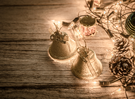 christmas jingle golden bell deco with rusty gold light bulb on wood background with copy spaceの写真素材