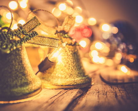 christmas jingle golden bell deco with rusty gold light bulb on wood background with copy spaceの写真素材