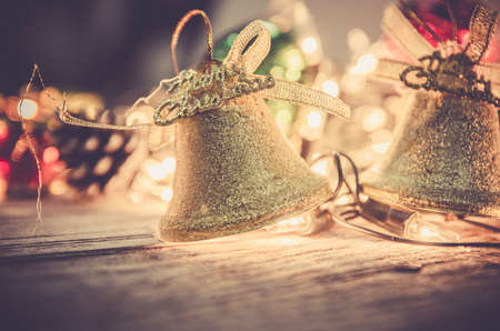 christmas, jingle golden bell deco with rusty gold light bulb on wood background with copy spaceの写真素材