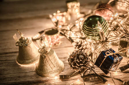 christmas jingle golden bell deco with rusty gold light bulb on wood background with copy spaceの写真素材