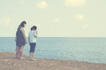 litttle family mother and kid stand on beach , color tone processの写真素材