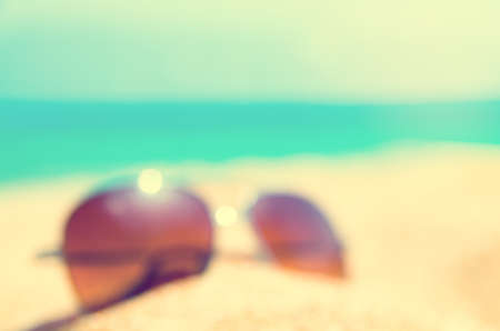 blurred abstract Fashion sunglass on the summer beach at ocean background , vintage filter , Summer vacation actually relaxing, summer concept , vocation time , summer backgroundの写真素材