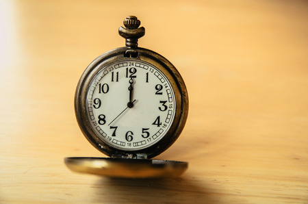 Old pocket watch on wooden tableの写真素材