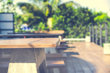 Wood table top on blur background of people in coffee shop, lomo and vintage tone effects の写真素材