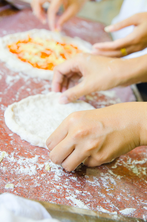 Close-up the hand of a baker kneading and shaping doughの写真素材