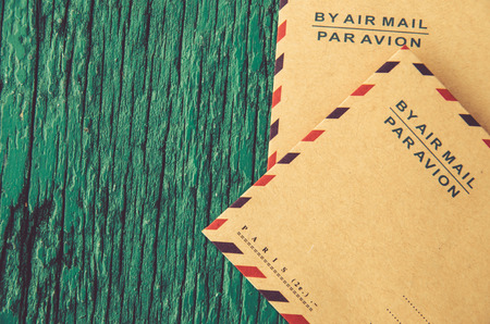 Blank paper card with brown envelop on wooden boardの写真素材