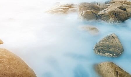 Sea waves lash line impact rock on the beachの写真素材