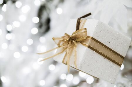 white Christmas gift box  with gold ribbon  and copyspace for your greeting or wishesの写真素材