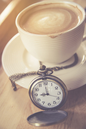 vintage pocket watch with coffee cupの写真素材
