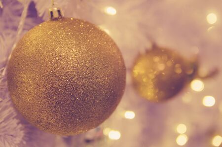christmas ornaments gold ball and light bulb on christmas treeの写真素材