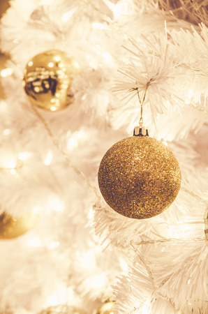 christmas ornaments gold ball and light bulb on christmas treeの写真素材