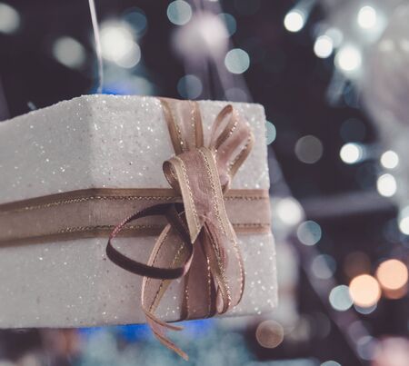 white Christmas gift box  with gold ribbon  and copyspace for your greeting or wishesの写真素材