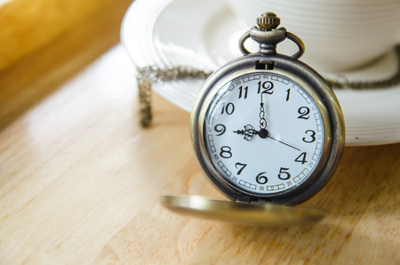 vintage pocket watch with coffee cupの写真素材