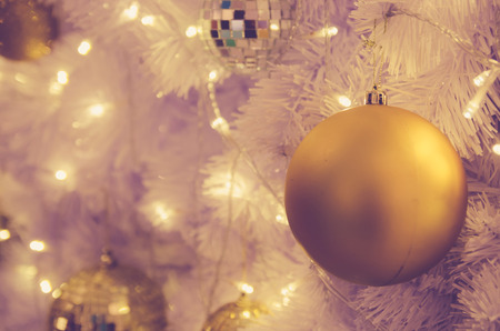 christmas ornaments gold ball and light bulb on christmas treeの写真素材