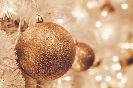 christmas ornaments gold ball and light bulb on christmas treeの写真素材