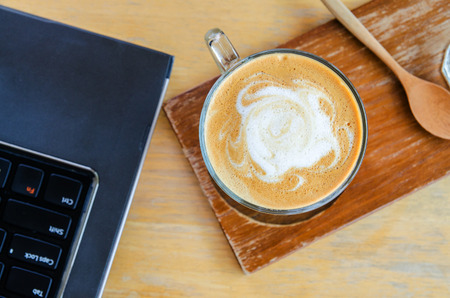 coffee cup on wood table with labtop office spaceの写真素材