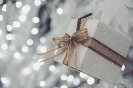 white Christmas gift box  with gold ribbon  and copyspace for your greeting or wishesの写真素材