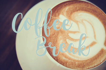 hot milk art coffee on wooden table with qoute on photoの写真素材