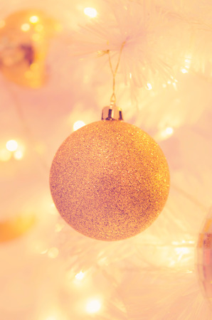 christmas ornaments gold ball and light bulb on christmas treeの写真素材