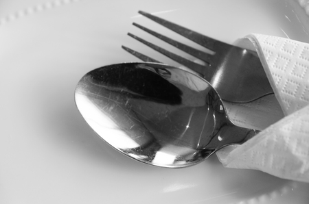 spoon and fork on plate in restaurantの写真素材