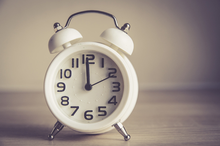 Retro alarm clock on a table. Photo in retro color image styleの写真素材